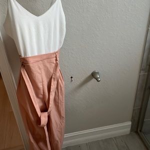 Pink and white one piece suit with a tie to make  a bow